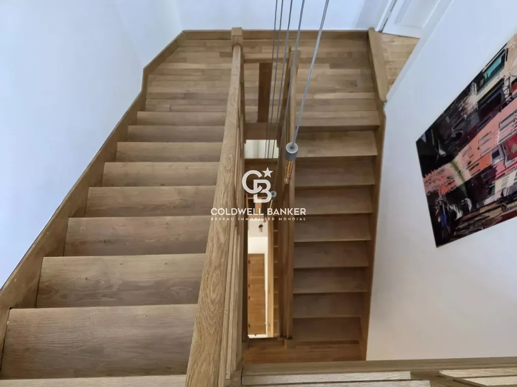 Escalier en bois massif desservant les étages d'une maison de sept chambres