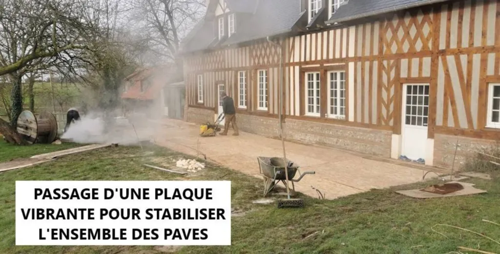 Passage d'une plaque vibrante pour stabiliser l'ensemble des pavés