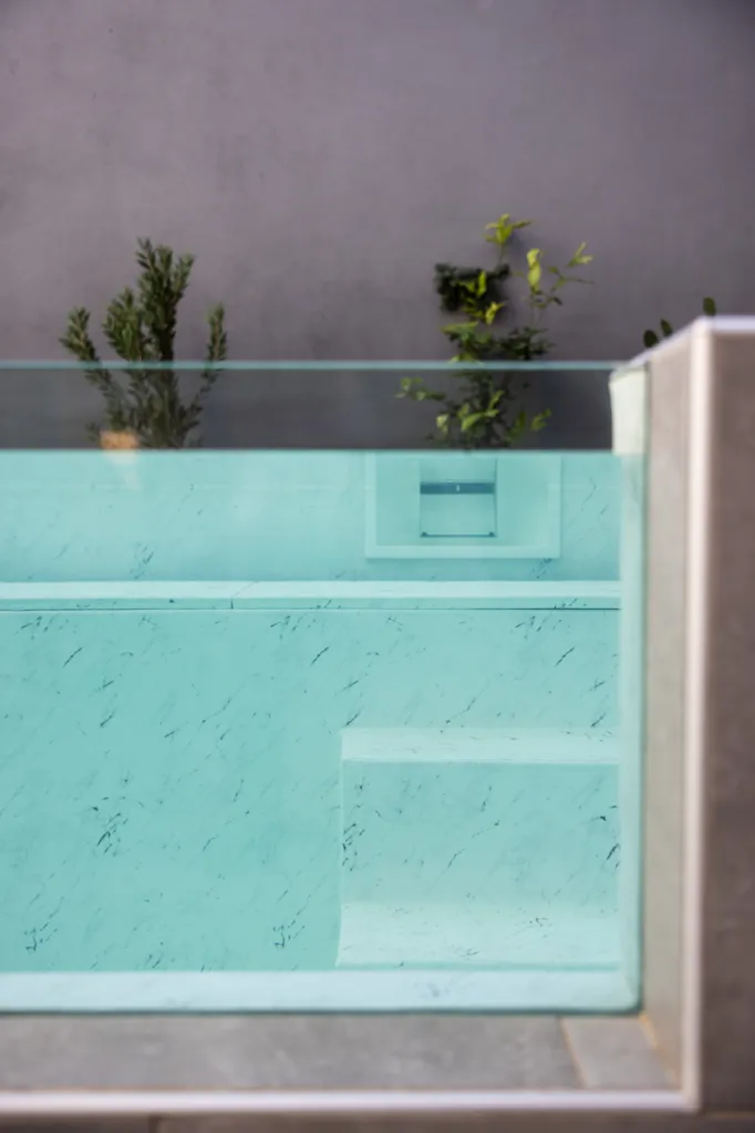 Piscine semi-enterrée avec paroi vitrée, PVC armé 3D et local technique compact à Nîmes centre-ville