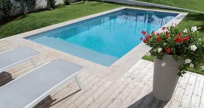 Réaliser une piscine rectangulaire élégante avec plage bois et margelles claires pour une maison à Aubagne proche de Gémenos