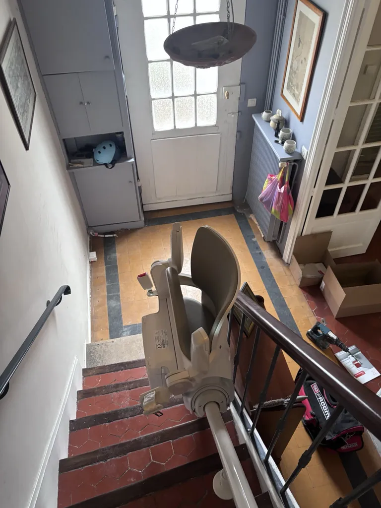 Fauteuil monte-escalier OTOLIFT Smart sur son point de charge libère ainsi le bas de l'escalier dans cette villa à Marseille