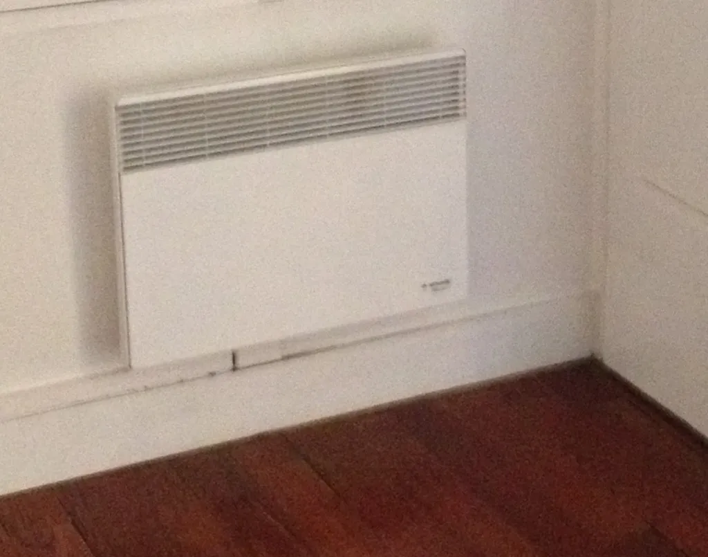 Ancien radiateur électrique type “grille-pain” énergivore, peu performant et responsable d’une consommation élevée dans une maison du Rhône (69)