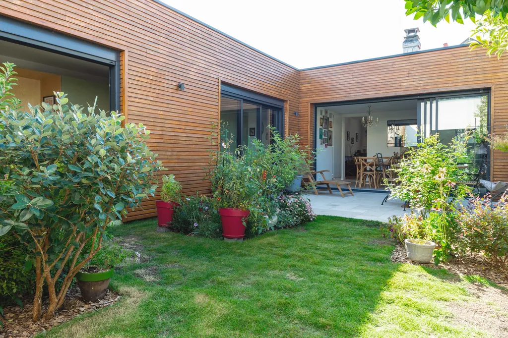 Projet d’agrandissement en rez-de-chaussée à Bègles conçu par AKIKO ARCHITECTURE : une architecture contemporaine en bois reliant deux volumes pour créer un cocon végétal autour du patio central