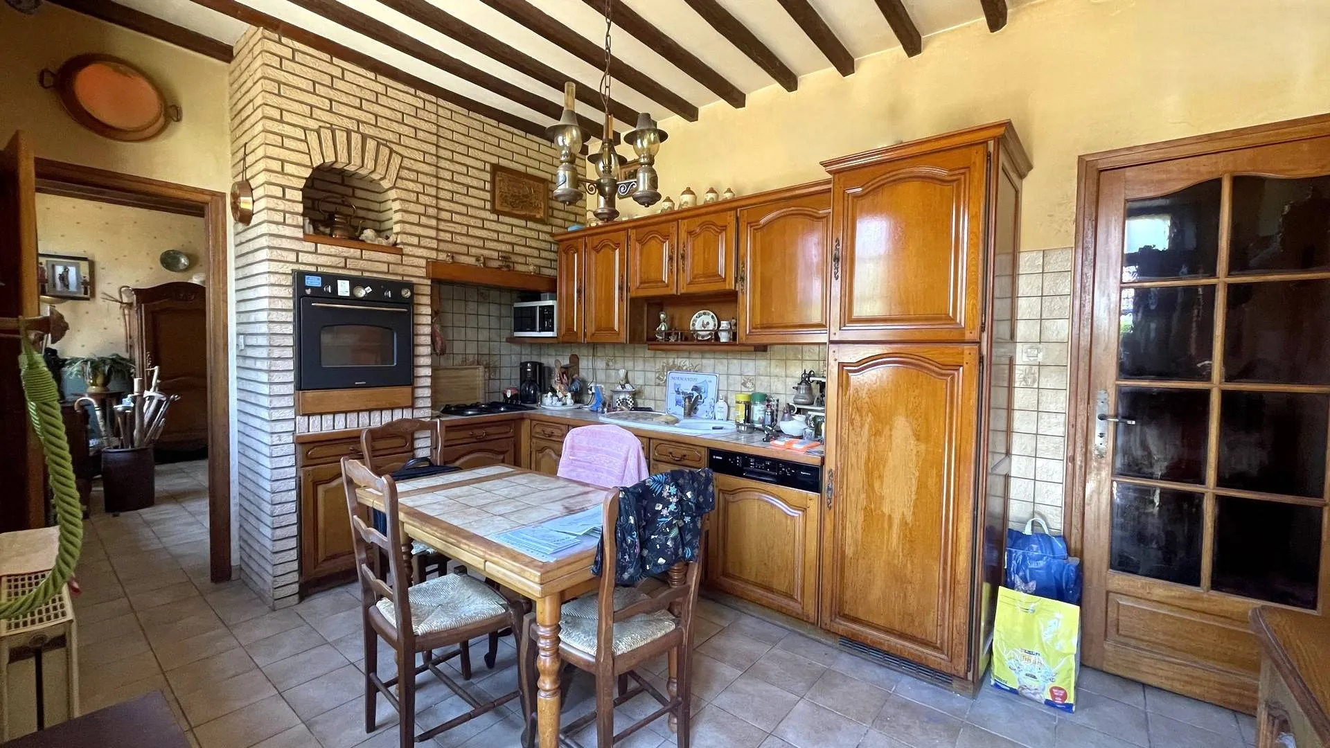 Maison à vendre avec cuisine authentique** : Entrée dans une cuisine conviviale avec accès direct au séjour.