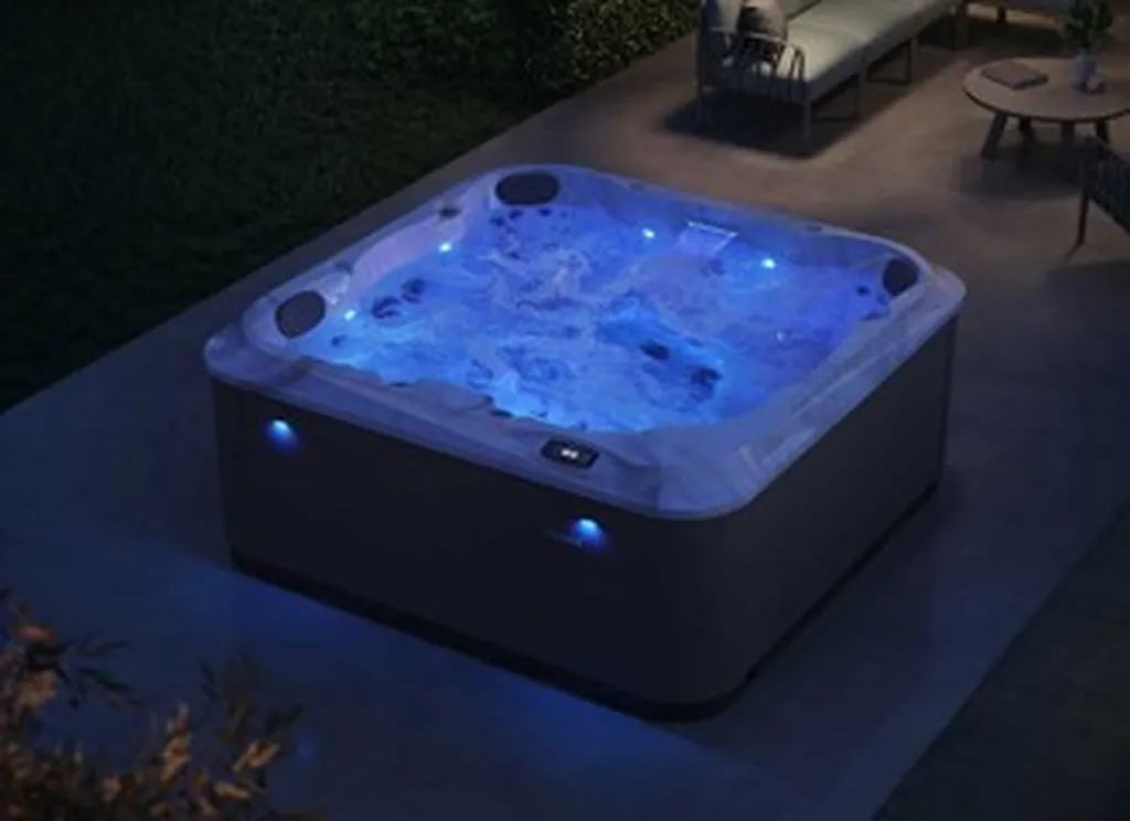 Jacuzzi J-201 allumé de nuit sur terrasse extérieur