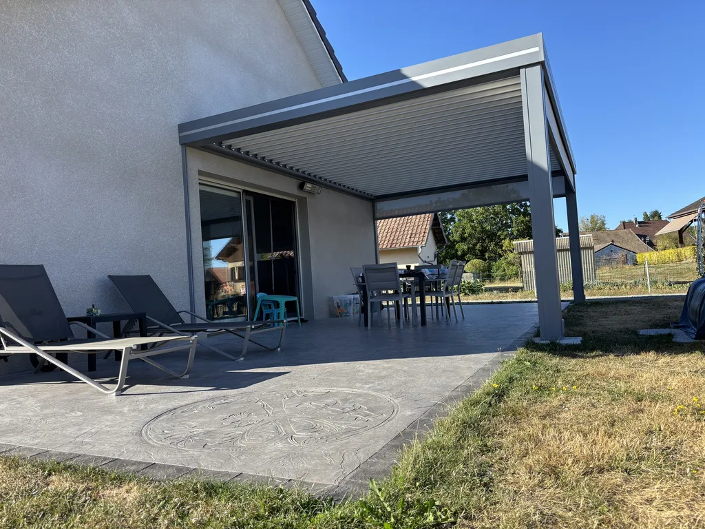 Découvrez la fourniture et pose d’une pergola bioclimatique 6 x 4 m à Anjoutey, dans le Territoire de Belfort. SB CONCEPT propose une installation avec lames orientables, stores intégrés