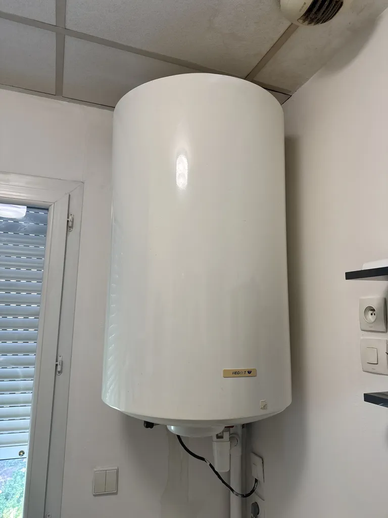 Installation de chauffe-eau électrique vertical blanc avec fixation murale et groupe de sécurité à Marseille et ses alentours