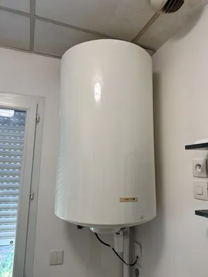 Installation de chauffe-eau électrique vertical blanc avec fixation murale et groupe de sécurité à Marseille et ses alentours