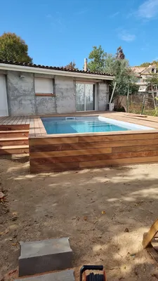 Une piscine traditionnelle intégrée au cœur d’un jardin toulousain sur mesure avec son volet roulant
