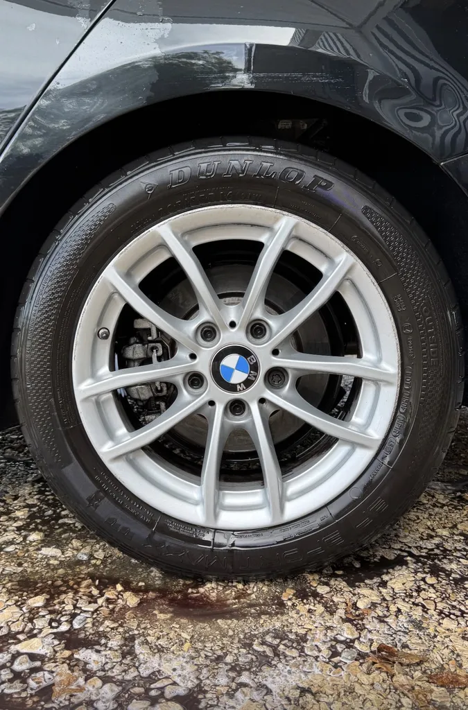 Nettoyage des pneus et jantes intégrale d'une BMW Série 1 pour redonner de la brillance au blanc des jantes à Genève en Suisse
