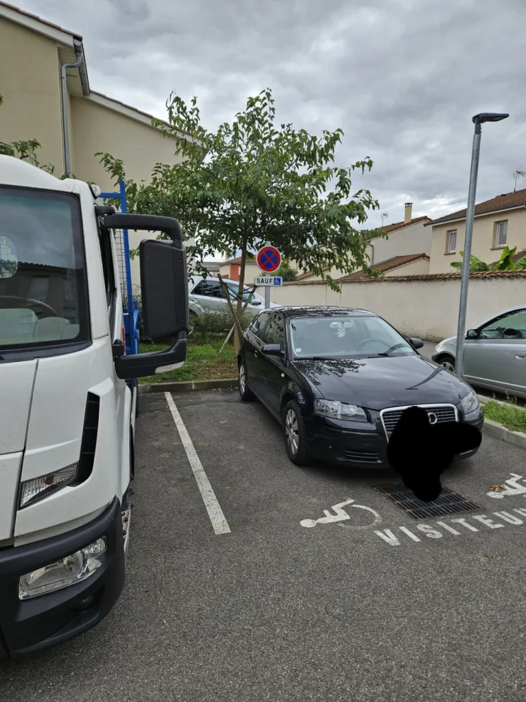 Pose d'un panneau de signalisation pour réserver le stationnement aux personnes en situation de handicap sur le parking d'une pharmacie à Décines à l'est de Lyon