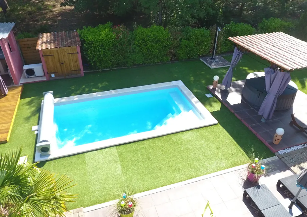 Piscine dans jardin avec pelouse