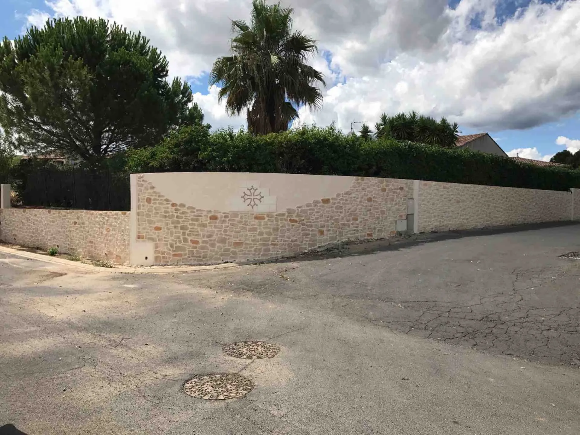 Clôture en pierre taillée avec cascade  et motif à Alignan du vent dans l'Hérault