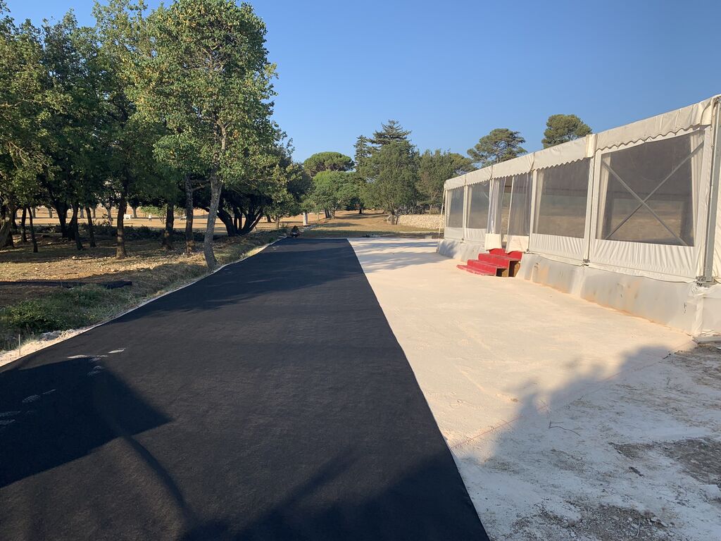 Installation complète de gazon synthétique haut de gamme autour d’un chapiteau pour réceptions et mariages à Lourmarin