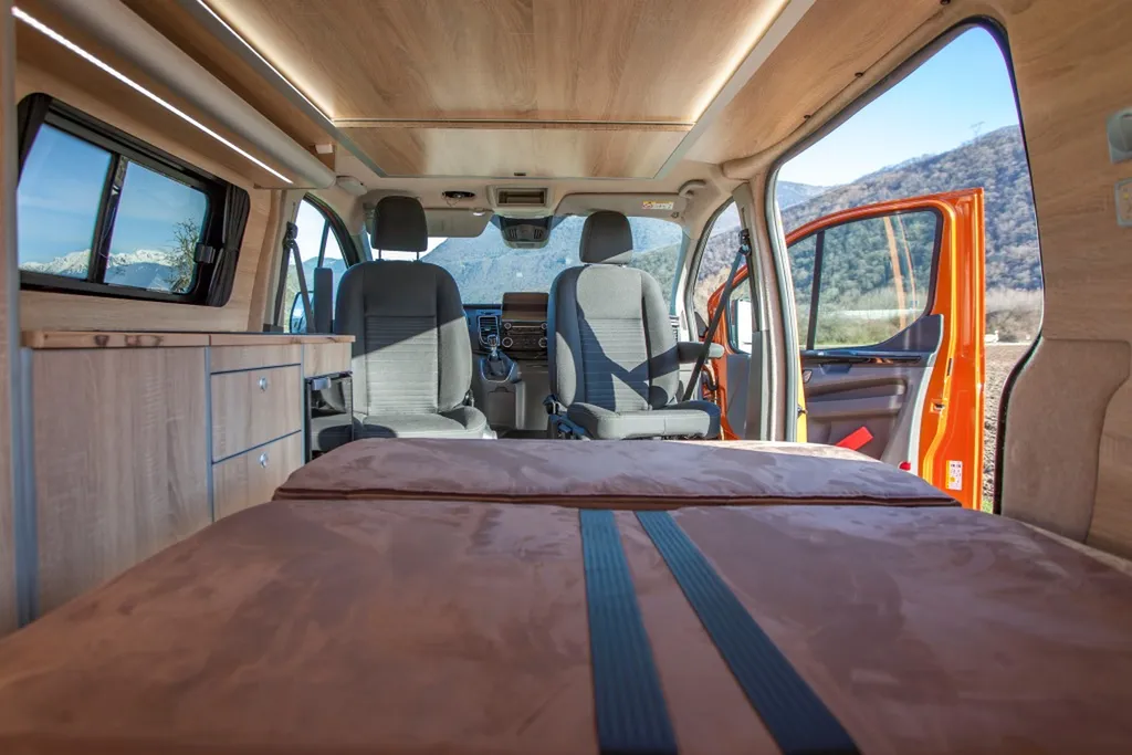 Pose de Banquette homologuée sur-mesure Ford Transit Custom L2H1 Long avec socle bois et transformation lit double posée à Annecy en Haute-Savoie