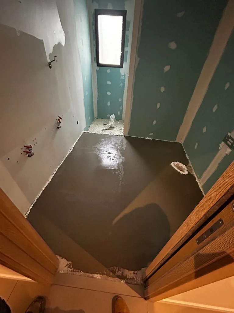 Application d'un enduit de lissage et ragréage de sol par notre entreprise RGE pour garantir une planéité parfaite avant la pose du carrelage