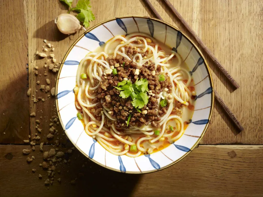 réalisation de photographie de plat culinaire pour restaurant nouilles dan dan au porc haché avec soupe