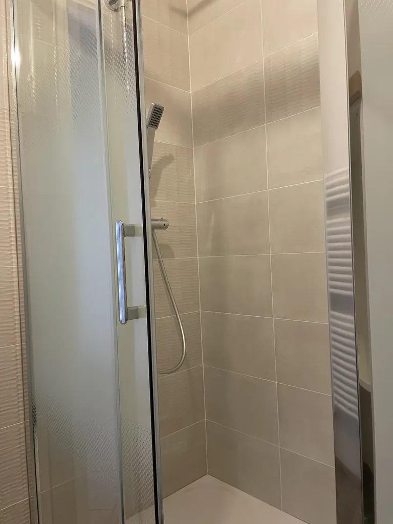 Paroi de douche en verre avec traitement anti-calcaire installée dans cette rénovation à Villeurbanne