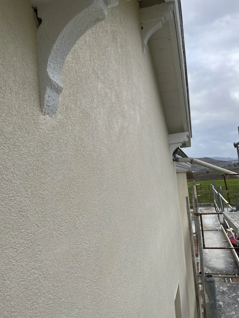 Finition de façade avec enduit et peinture après isolation thermique par l’extérieur pour améliorer l’esthétique et la performance énergétique de la maison