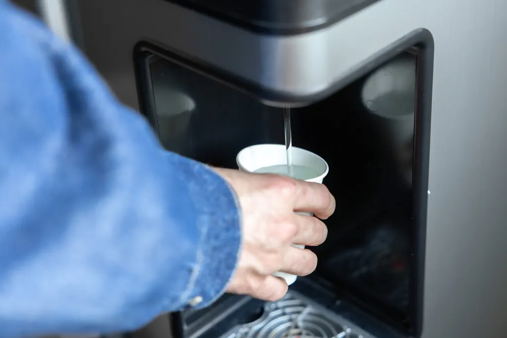 Remplissage d’un verre avec fontaine à eau entreprise – eau filtrée de qualité