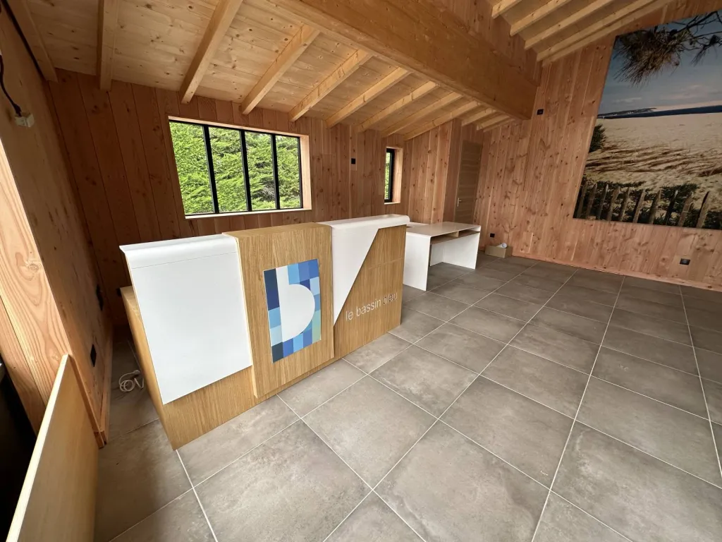 Banque d'accueil, bureau et toile rétro-éclairée dans un commerce à LEGE CAP FERRET (33)