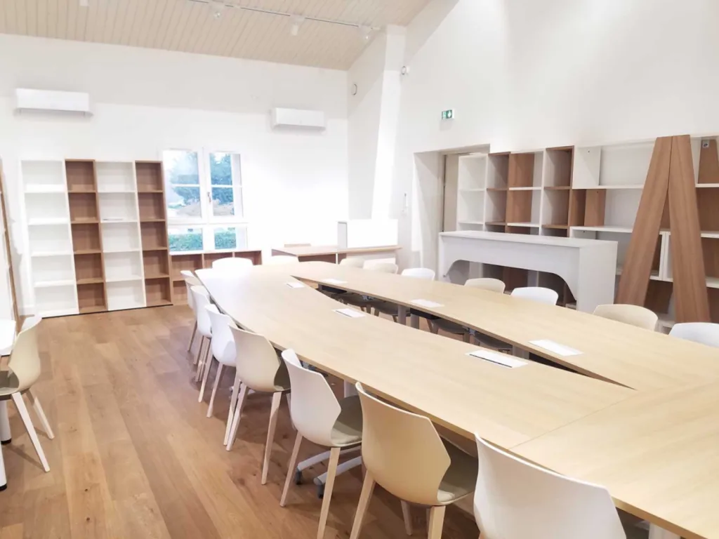 Réhabilitation de 200 m² de bureaux à Cheval-Blanc avec table de réunion 20 places, cafétéria colorée et design bois/blanc chaleureux