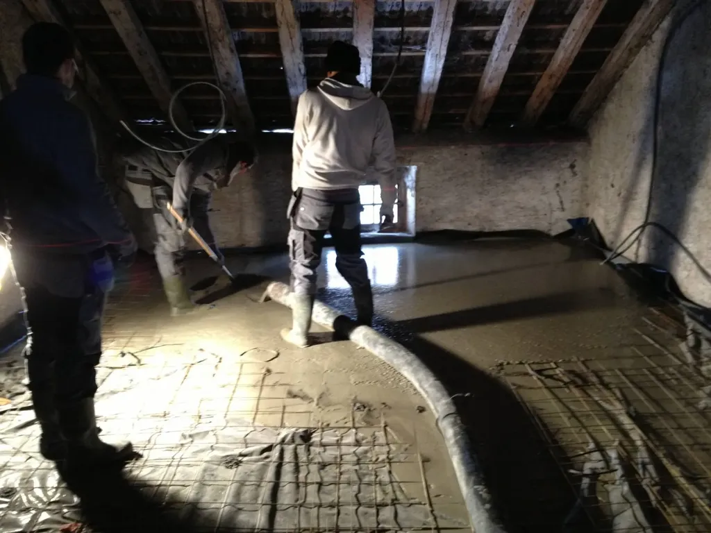 Coulage d’une dalle liquide en cours dans le Val de Saône pour créer un sol isolant et performant