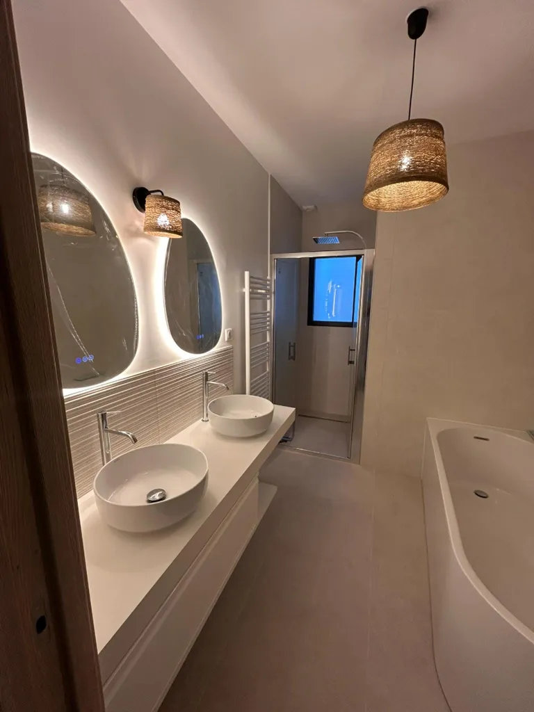 Salle de bain moderne et lumineuse avec sa douche à l'italienne sur mesure et sa faïence décorative texturée