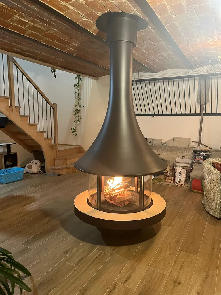 Cheminée centrale Bordelet EVA 992 dans un intérieur avec plafond brique et sol en parquet de bois