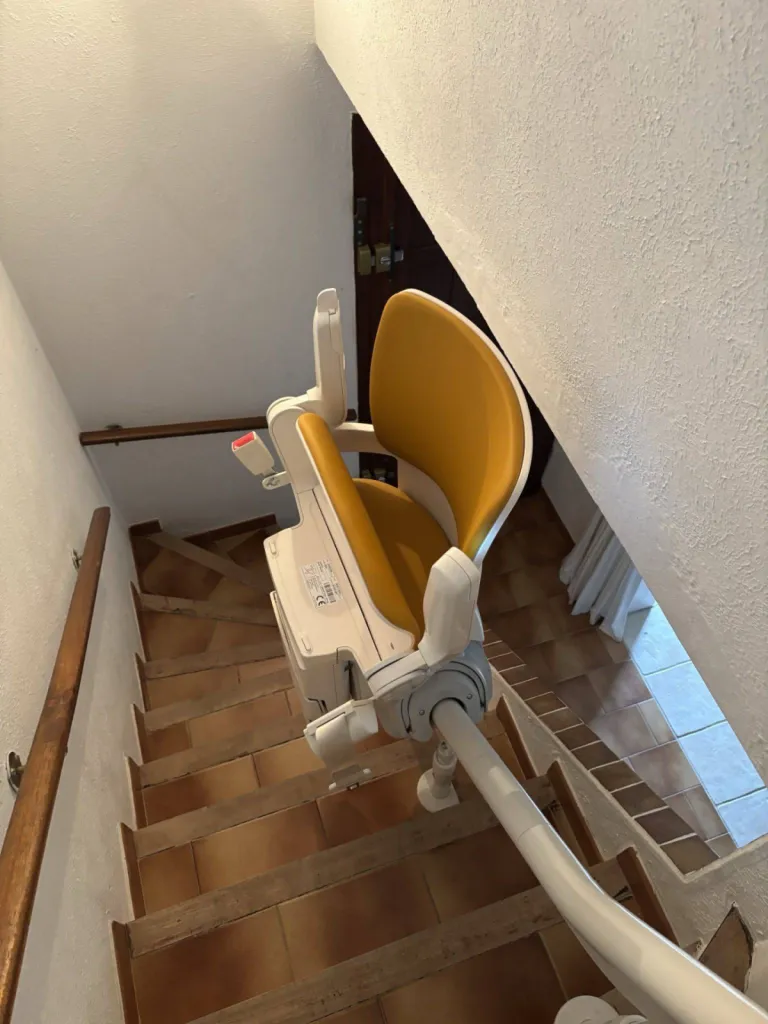 Le fauteuil monte escalier OTOLIFT Smart sur son point de charge intermédiaire dans cet escalier intérieur 2/4 tournant entre Manosque et Forcalquier