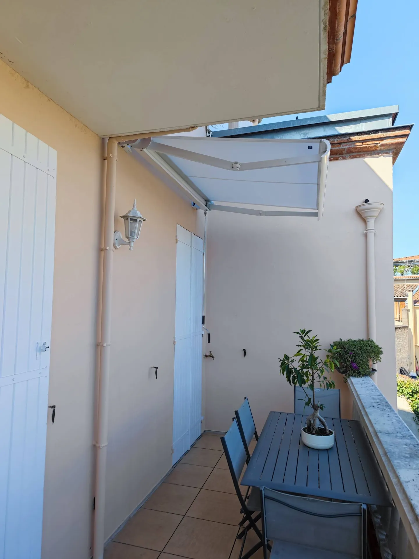 Installation murale d'un store manuel avec armature aluminium blanc et toile Dickson haute résistance