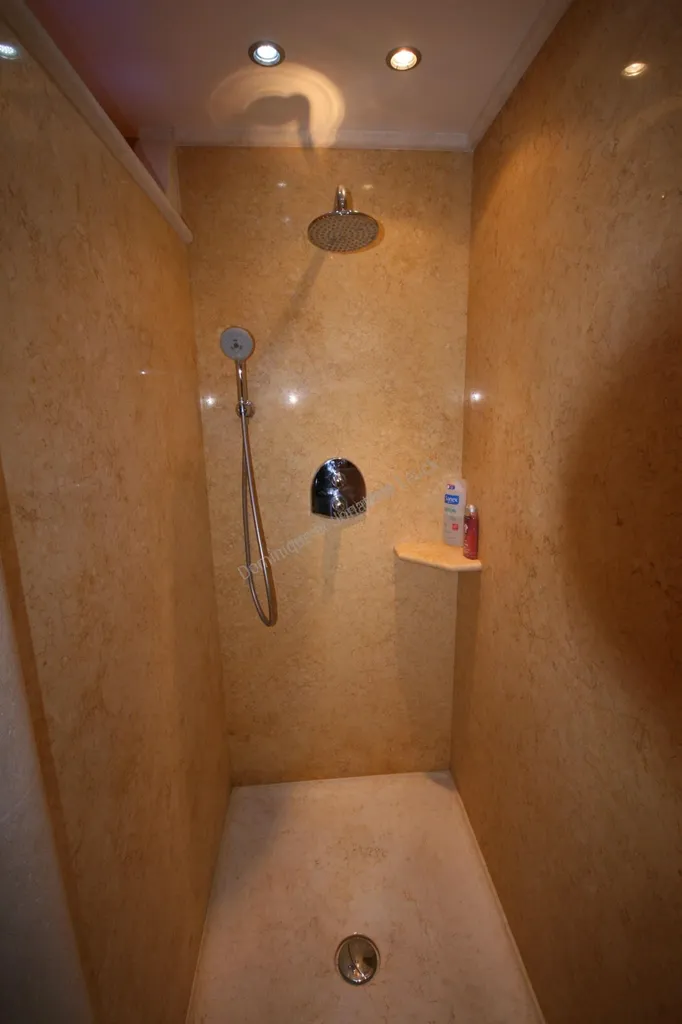 Grande paroi de douche en marbre d'Egypte (jaune atlantide) et le receveur de douche en massif dans le même marbre, situé vers Saint Remy de Provence proche de Cavaillon