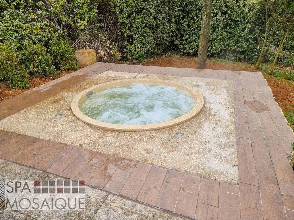 Un spa mosaïque carrelé encastré dans une terrasse en béton à Aix-en-Provence