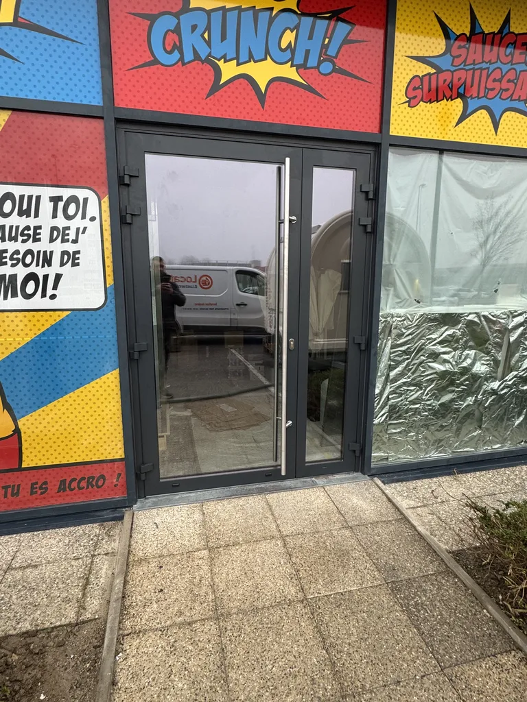 Installation d'une porte d'entrée technique à deux vantaux Aliplast ECO FUTURAL gris anthracite 7016 avec rampe PMR et ferme-porte Geze à Strasbourg dans le Bas-Rhin