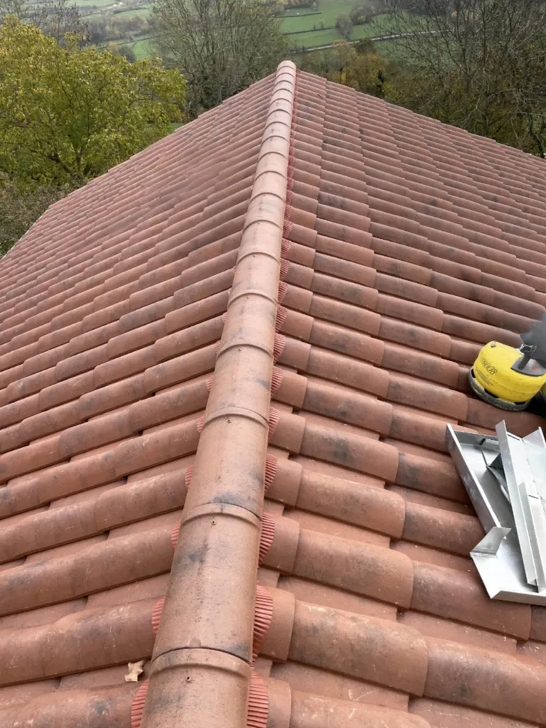 Pose de nouvelles tuiles sur toiture après rénovation pour garantir étanchéité, durabilité et esthétique