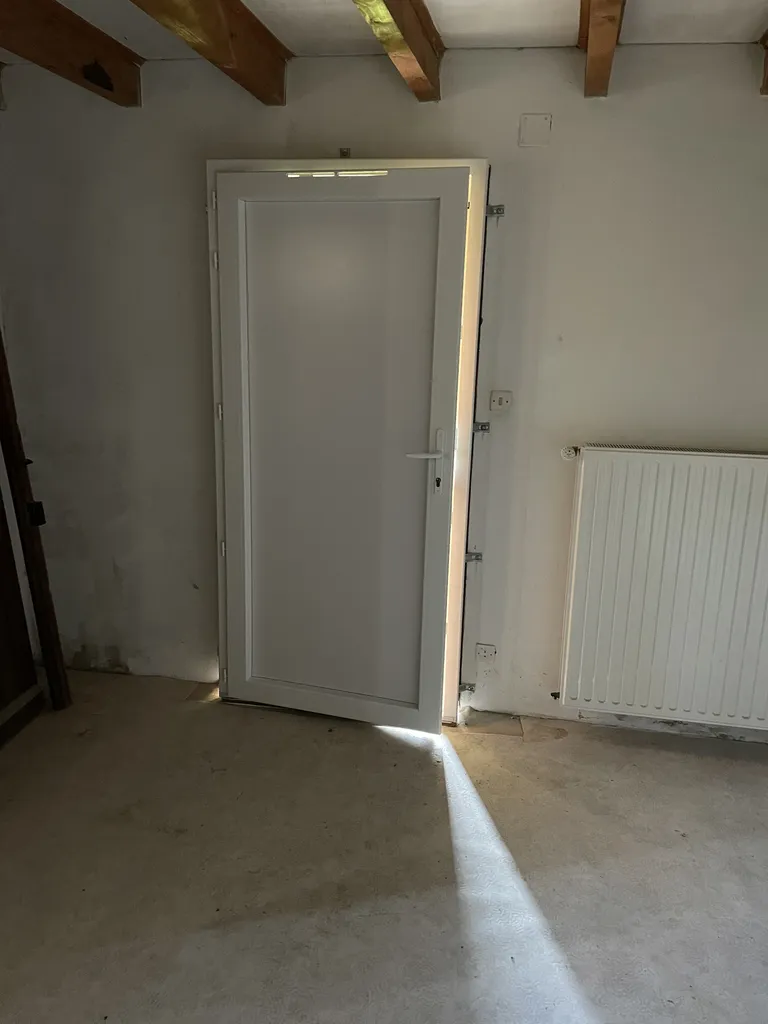 Pose en applique d’une porte d’entrée en PVC avant isolation thermique intérieure lors d’une rénovation énergétique de maison à Beaujeu (Rhône 69) pour améliorer l’isolation thermique et l’étanchéité à l’air