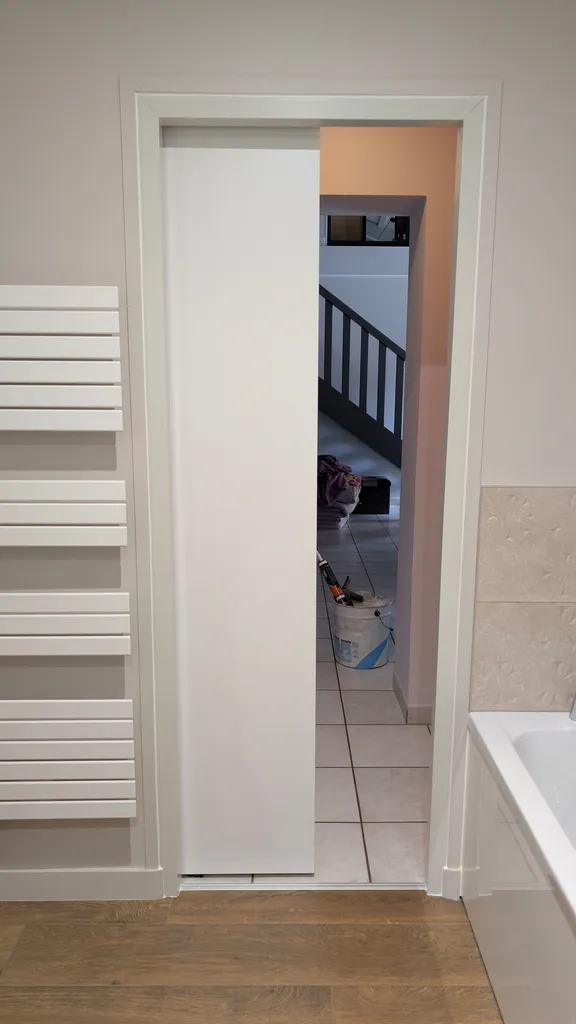 ​Pose d’une porte coulissante intérieure blanche avec rail apparent noir à Biziat