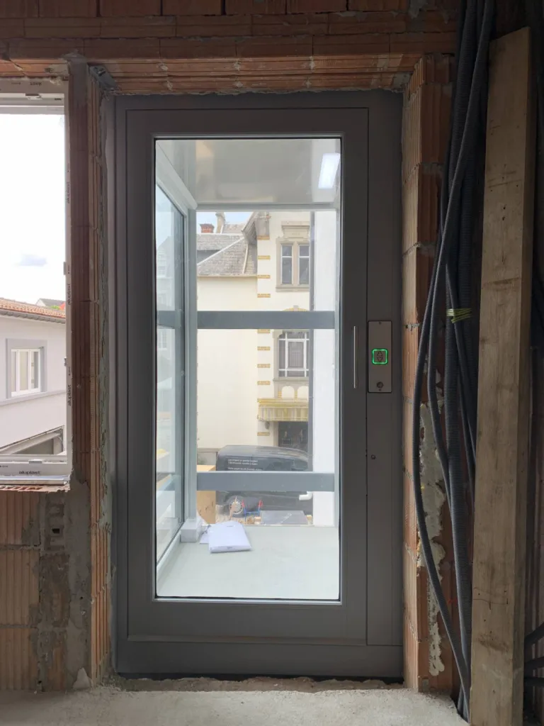 Installation d'un élévateur vertical électrique en pylone verre transparent auporteur en extérieur près d'Orange en Vaucluse