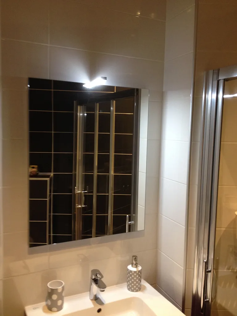 Installation d’un meuble vasque avec miroir éclairé lors de la rénovation d’une petite salle de bains à Lyon (Rhône – 69)