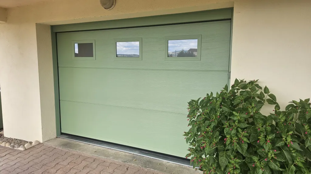 Pose d'une porte de garage motorisée radio, coloris vert olive avec hublots sécurisés à Chazelles-sur-Lyon près d'Andrézieux-Bouthéon (42) par 3 Baies