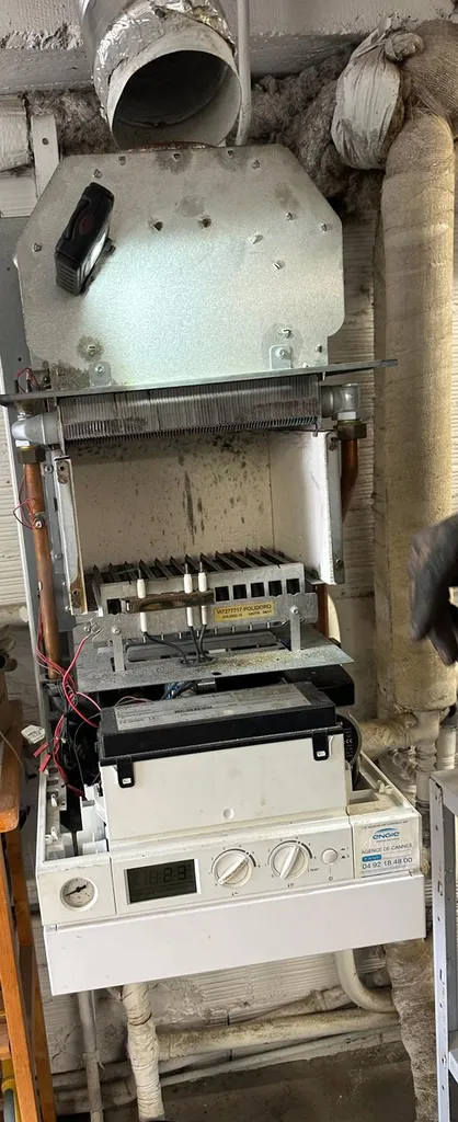 Chaudière gaz ouverte lors d'une intervention de ramonage à Grasse. Cette opération permet de contrôler l'état général de l'installation, de vérifier l'évacuation des fumées et d'assurer un fonctionnement sécurisé et performant du système de chauffage. Un