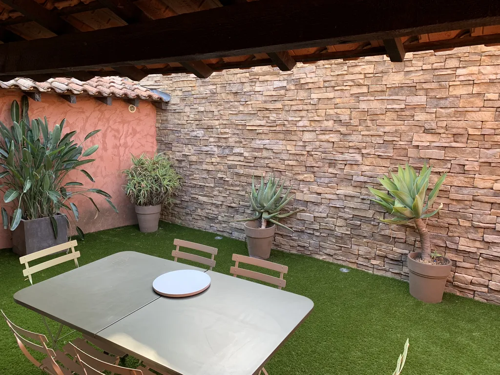 Création d’un patio contemporain avec parement de pierre et gazon synthétique