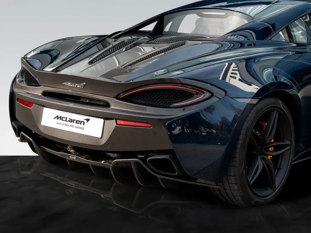 Vue arrière de la McLaren 570S bleue montrant diffuseur et lignes aérodynamiques.