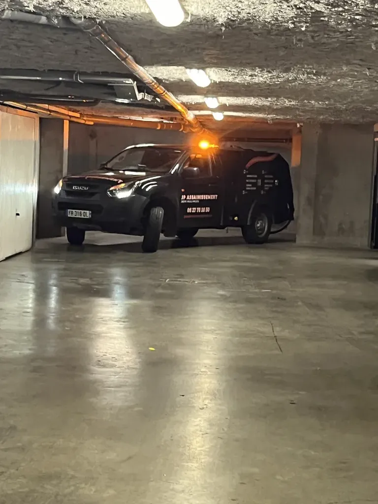 Vidange et entretien des caniveaux avec un mini hydrocureur dans le sous-sol d'une copropriété à Tignieu-Jameyzieu en Isère
