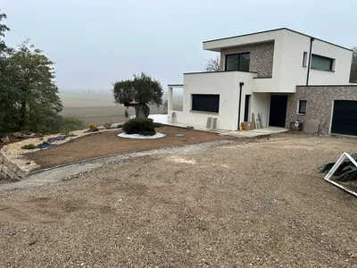 Aménagement extérieur complet à Cailloux-sur-Fontaines : terrassement, mur de soutènement en enrochement et empierrement de cour de maison contemporaine