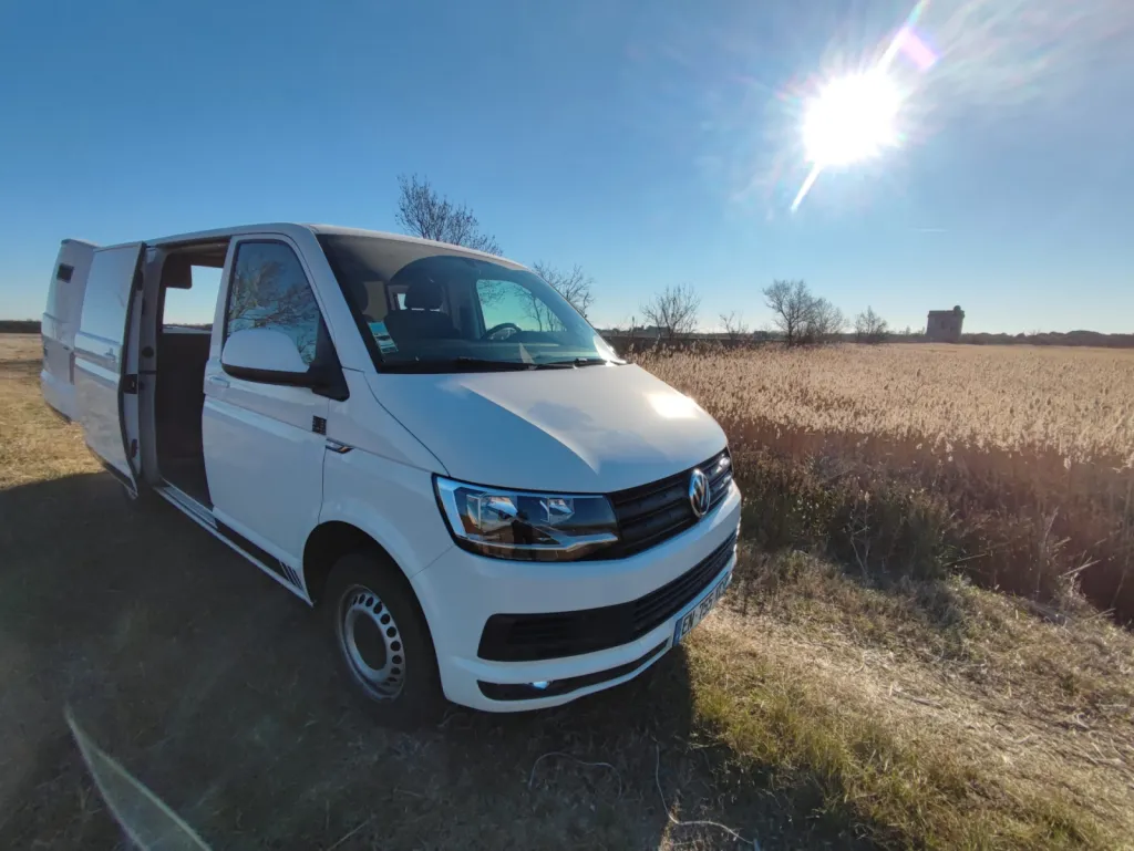 Aménagement complet d’un VW Transporter T6 avec isolation recyclée, toit relevable, mobilier sur mesure, équipements solaires et confort optimal pour voyager toute l’année en Occitanie