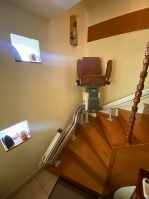 Installation d'un monte-escaliers tournants électrique avec fauteuil en cuir coloris Cognac de la marque UP sur escaliers intérieurs en bois à Romagnat près de Chamalières dans le Puy-de-Dôme par 3 Baies