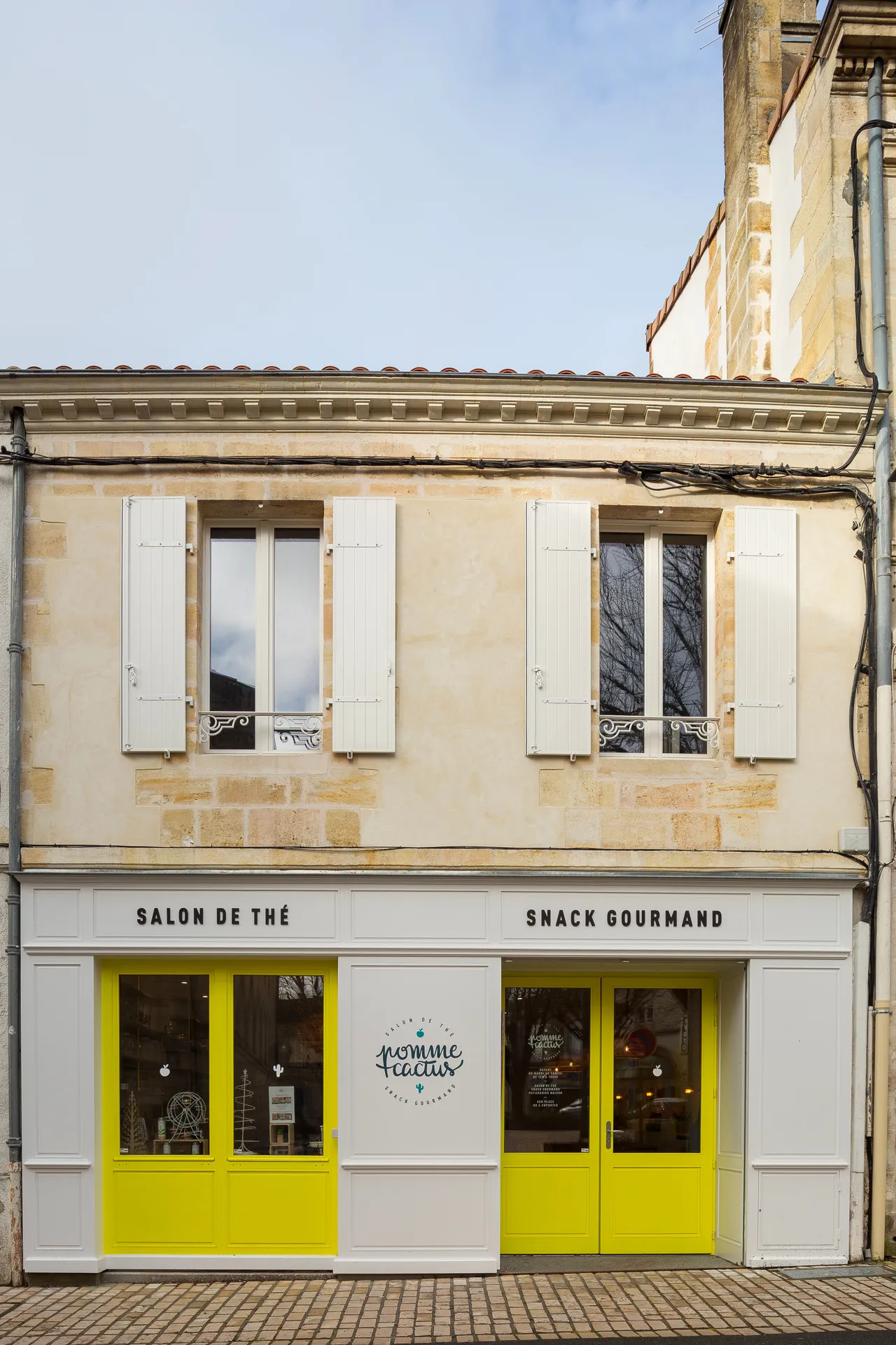 AKIKO ARCHITECTURE – Blanquefort / Taillan-Médoc – Rénovation & réagencement La façade a été subtilement réinventée : menuiseries jaune vitaminé, encadrement blanc épuré et identité visuelle intégrée. L’agence redonne vie à cette boutique du centre histor