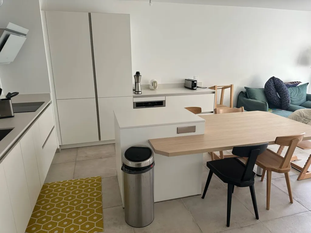 Conception de cuisine avec îlot central et table intégrée à Lyon